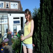 Hairy mature lady playing with the hose in the garden